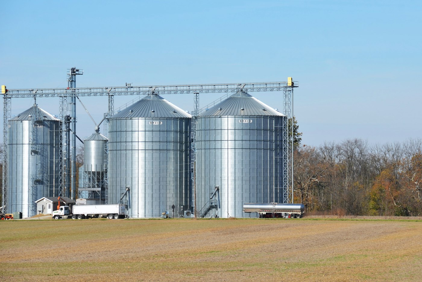Farm silos and a tractor in front of a field