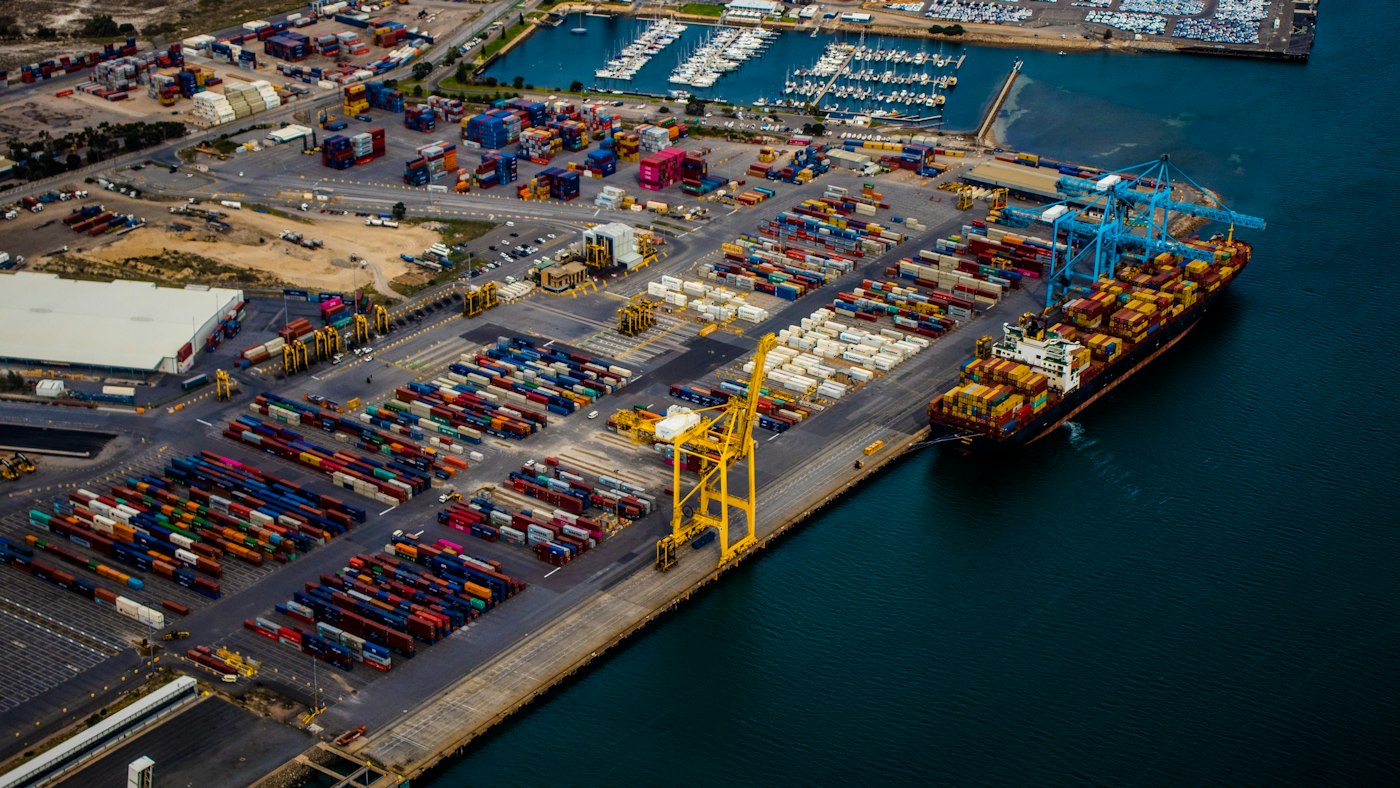 Container ship moored at a port under cranes